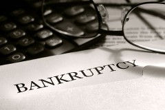 a bankruptcy notice letter with calculator and eyeglasses